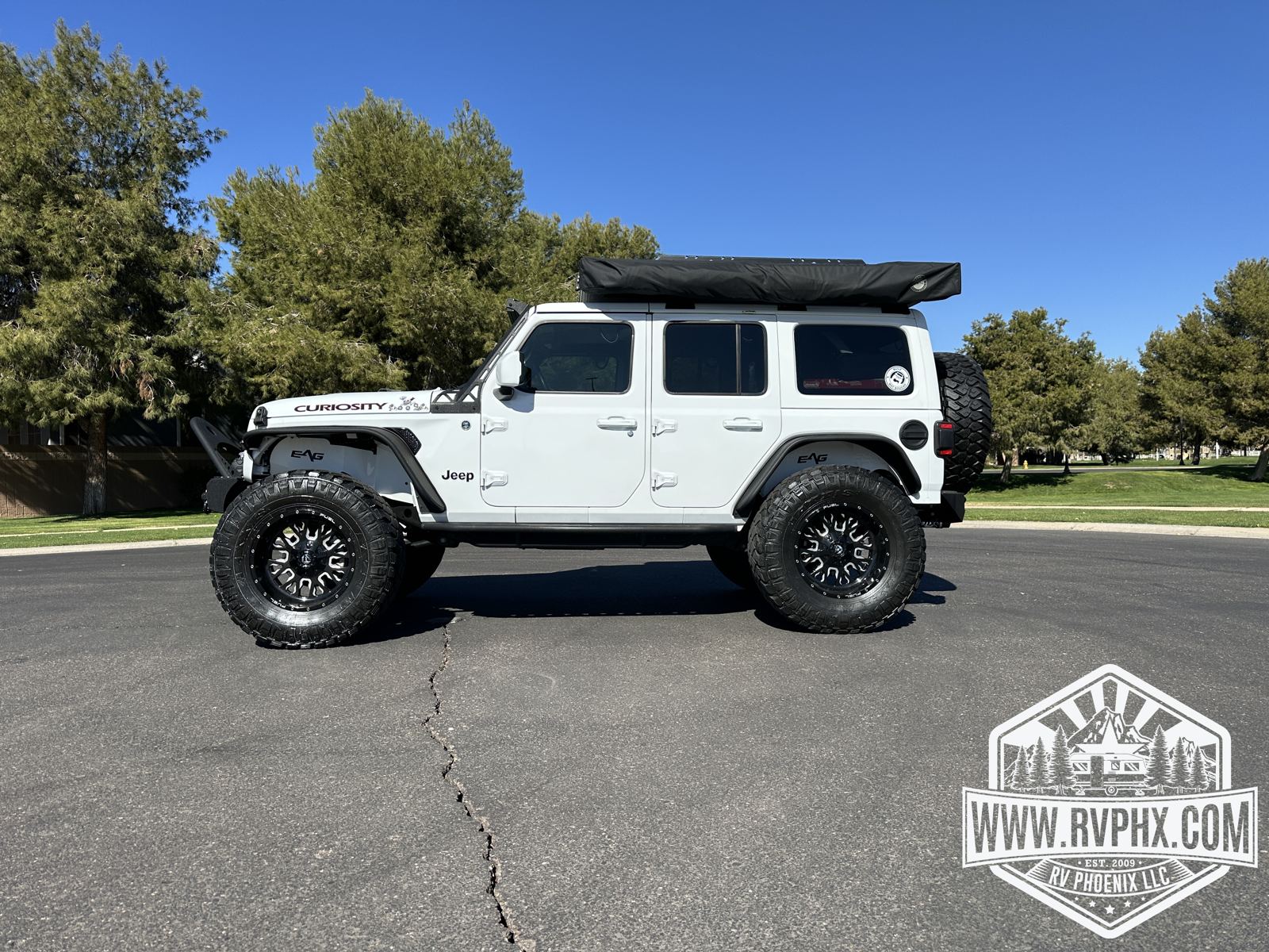 Side profile of the lifted Jeep Wrangler Unlimited with low-profile rooftop tent and off-road tires