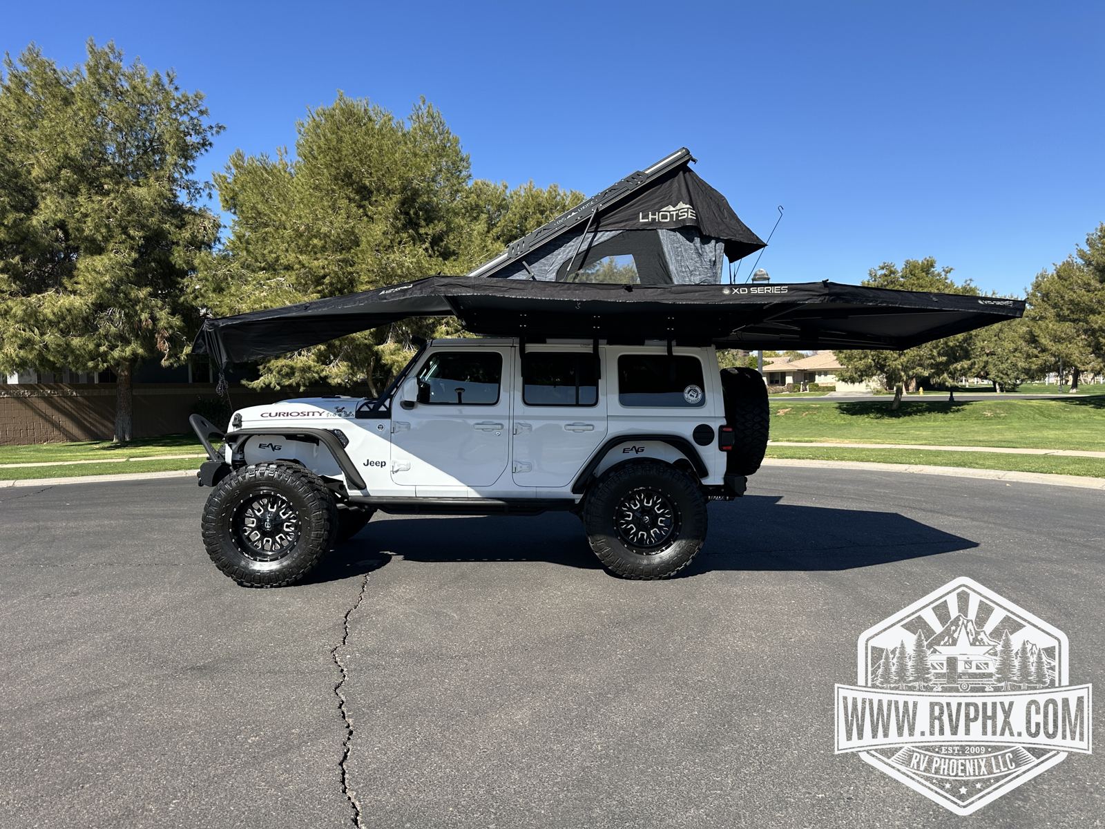 270-degree awning deployed with the rooftop tent open, shading the side of the Jeep